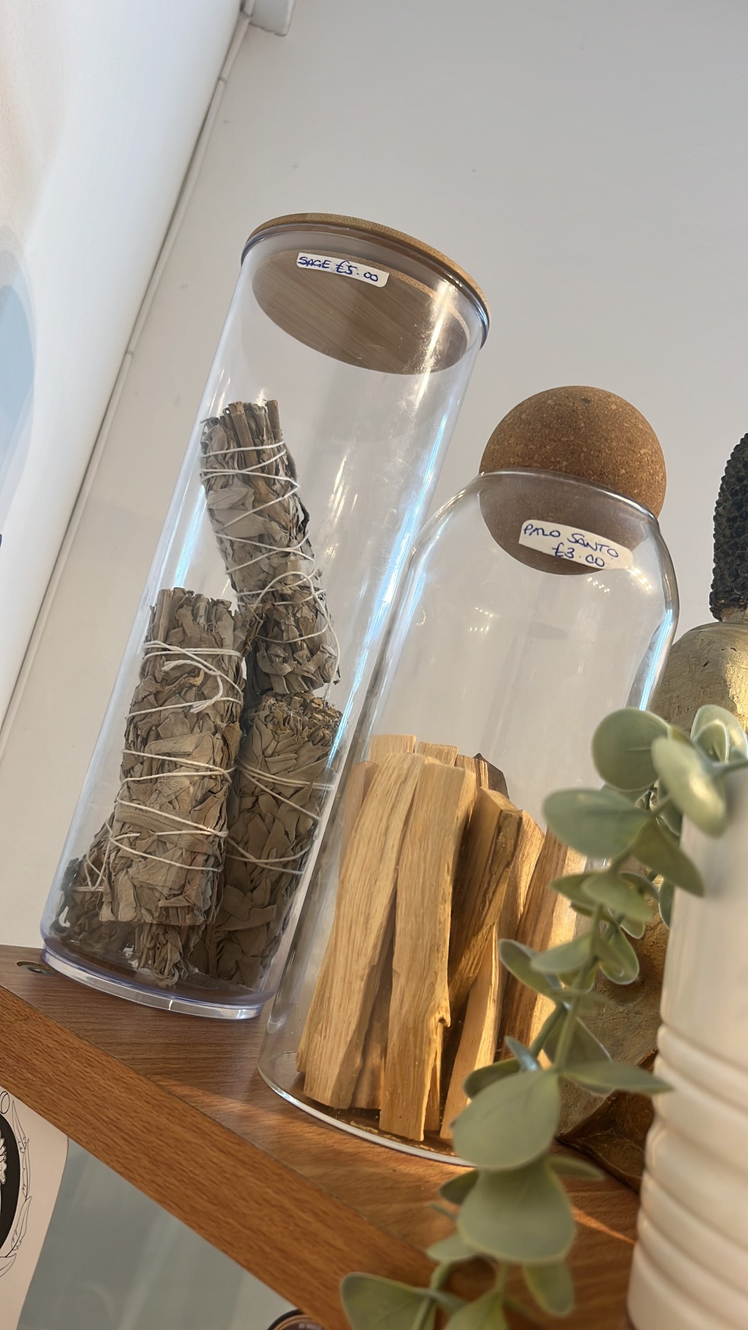 Sage and palo santo in glass jars on the shop shelf
