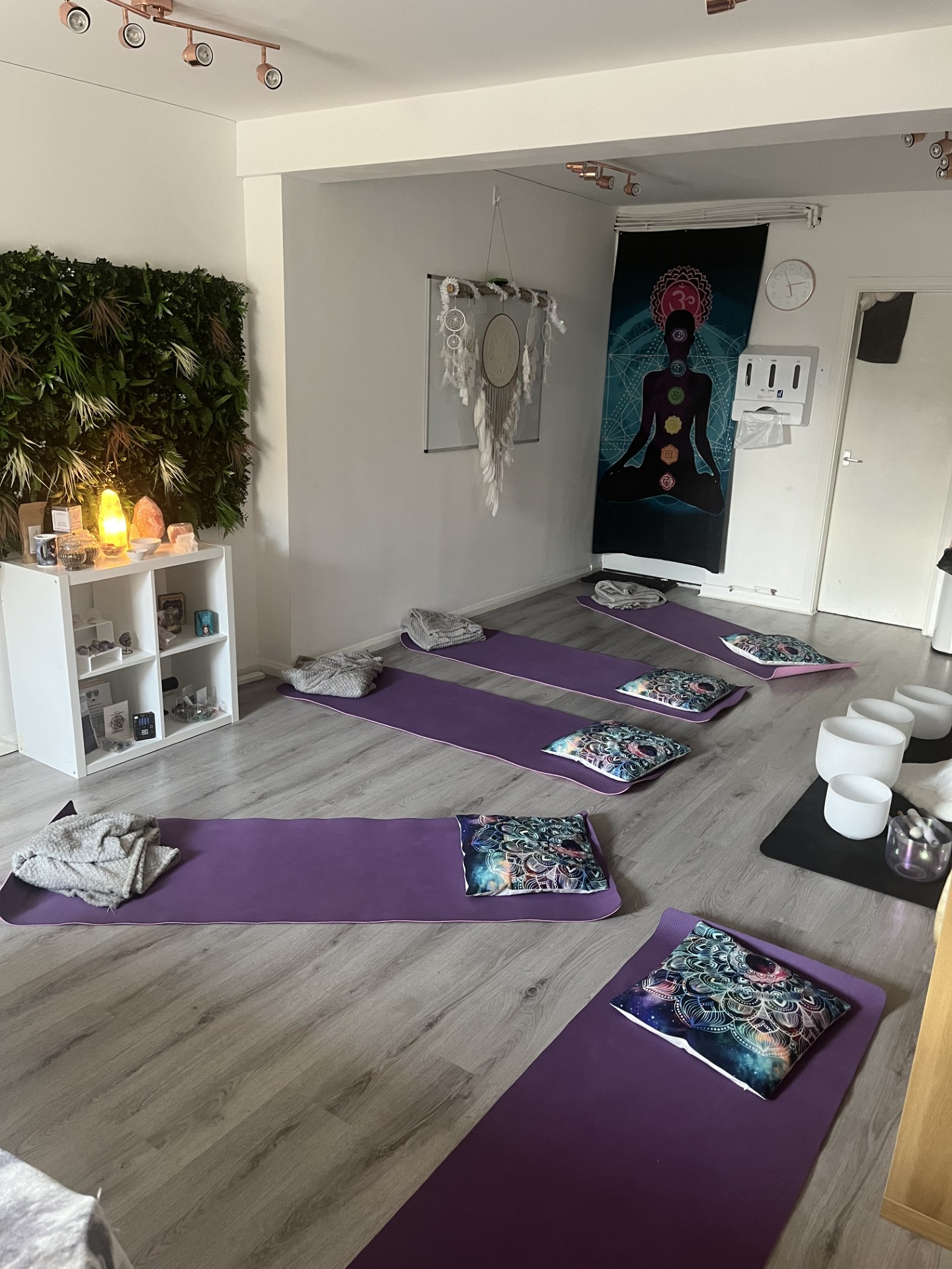 The daylit sound bath room with mats, cushions, blankets and singing bowls