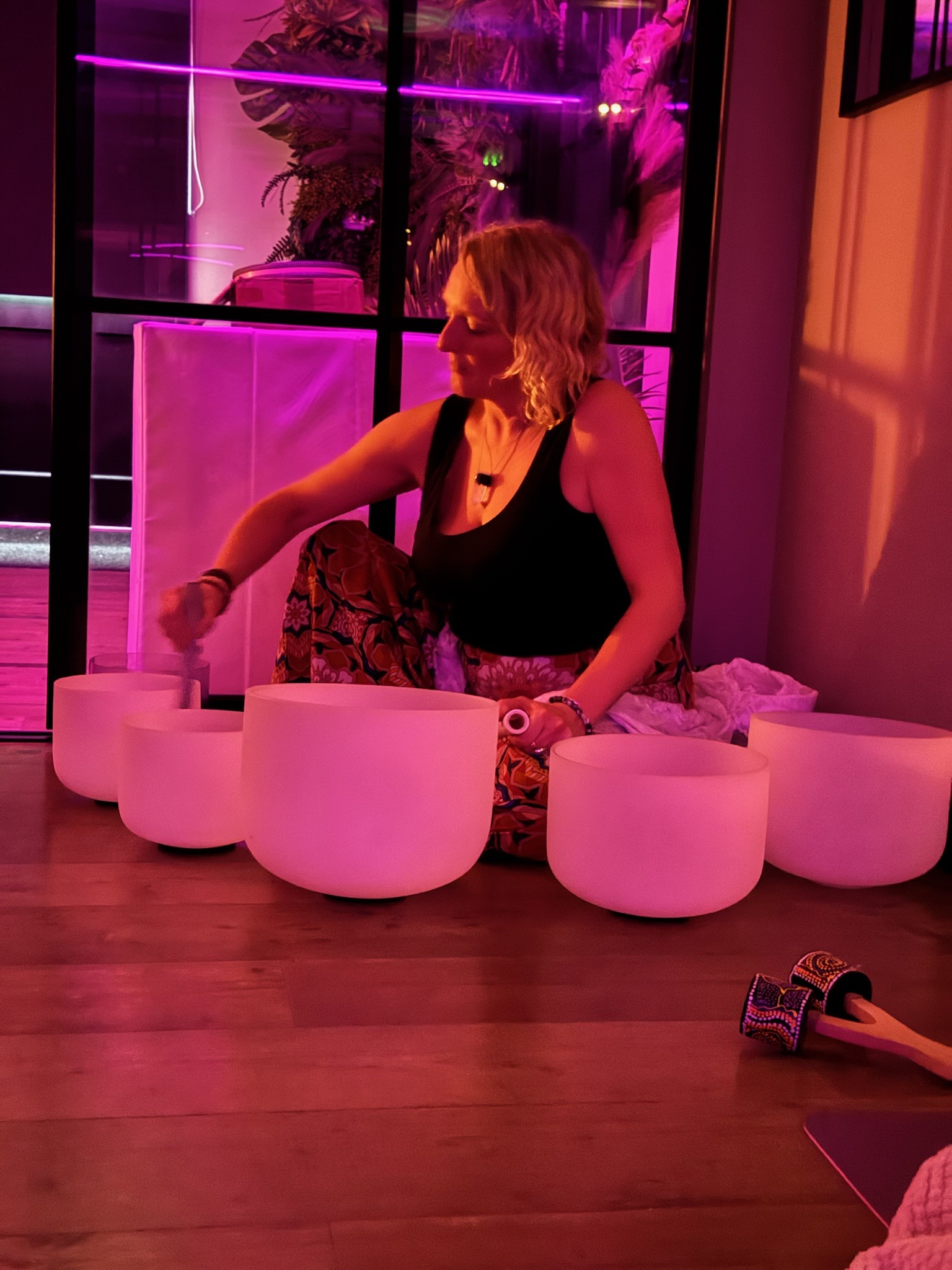Crystal singing bowls during a softly lit sound bath
